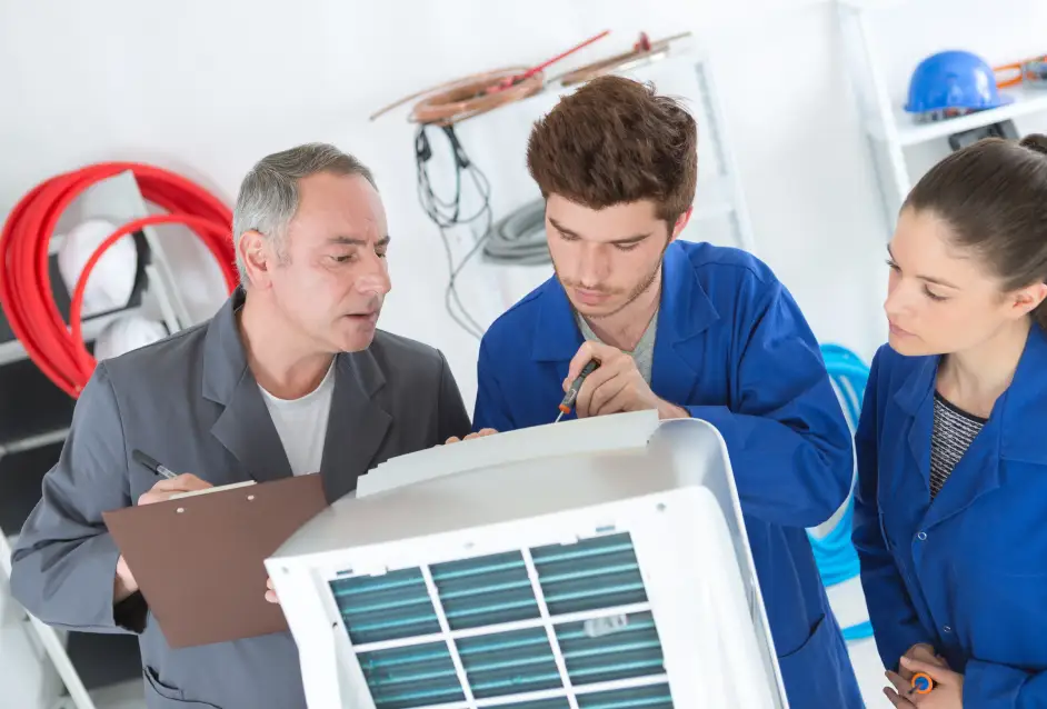 A team of HVAC techniciansreviewing a heating and cooling system.