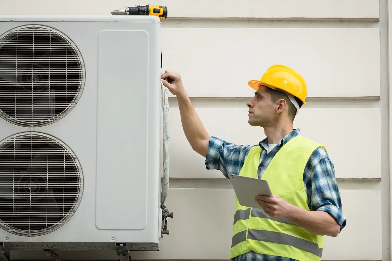 A man installing a heat pump